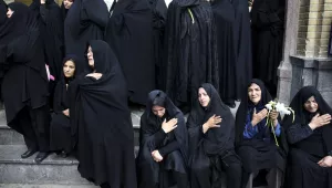In this June 25, 2015 file photo, Iranian women mourn during the funeral ceremony of Ali Amraei and Hassan Ghaffari, who were killed in fighting against Islamic State extremists in Syria, in southern Tehran, Iran. The protests that broke out in late December 2017 across Iran predominantly involve economic issues, but demonstrators also say the government is sending its young men to fight and die in Syria and spending billions of dollars on the military when it should be focused on providing jobs in Iran. 