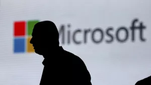 In this Nov. 7, 2017, file photo, an unidentified man is silhouetted as he walks in front of Microsoft logo at an event in New Delhi, India. Microsoft says it's committing to giving users worldwide the same data and privacy rights being offered to Europeans under new regulations there. That means no matter where you live, you'll be able to see what Microsoft collects about you and correct or delete that information if necessary. 