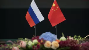 Russian and Chinese flags sit side by side on a table in the Great Hall of the People, Beijing, on June 8, 2018.