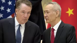 U.S. Trade Representative Robert Lighthizer and Chinese Vice Premier Liu He talk in front of the US and China flags. 