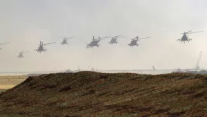 Military helicopters fly over the training ground during strategic command and staff exercises Center-2019 at Donguz shooting range near Orenburg, Russia, Friday, Sept. 20, 2019. 