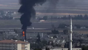 In this photo taken from the Turkish side of the border between Turkey and Syria, in Ceylanpinar, Sanliurfa province, southeastern Turkey, smoke billows from a fire in Ras al-Ayn, Syria, Friday, Oct. 18, 2019.