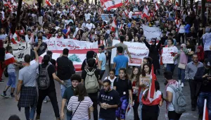 University students hold Lebanese flags as they chant slogans against the government, in Beirut, Lebanon, Tuesday, Nov. 12, 2019.