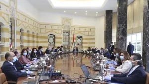 In this photo released by the Lebanese Government, President Michel Aoun, center, and government ministers wear masks to help protect themselves from the coronavirus, while attending a cabinet meeting at the presidential palace in Baabda, east of Beirut. 