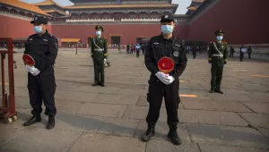Chinese paramilitary police and security officers wear face masks to protect against the spread of the new coronavirus as they stand guard outside an entrance to the Forbidden City in Beijing, Friday, May 1, 2020. (AP Photo/Mark Schiefelbein)