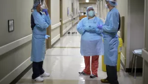 Dr. Drew Miller, right, talks with respiratory therapist Jade Carabajal-Richter, center, and registered nurse Kevin Hoover after checking on a COVID-19 patient at Kearny County Hospital in Lakin, Kansas. 