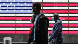 Pedestrians wear protective masks as they walk in Times Square during the coronavirus pandemic, Saturday, May 23, 2020, in New York.