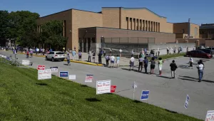 Voters wait in a line outside Broad Ripple High School to vote in the Indiana primary in Indianapolis, Tuesday, June 2, 2020 after coronavirus concerns prompted officials to delay the primary from its original May 5 date.