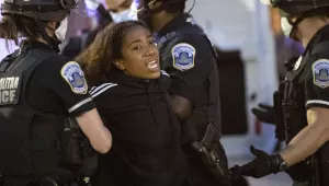 Photo of Metropolitan Washington D.C. police officers arresting a young woman demonstrator as she cries after they gathered to protest the death of George Floyd, Monday, June 1, 2020, near the White House in Washington. 