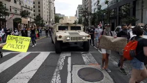 Photo shows demonstrators marching past a military humvee as they protest the death of George Floyd, Tuesday, June 2, 2020, in Washington. Floyd died after being restrained by Minneapolis police officers. 