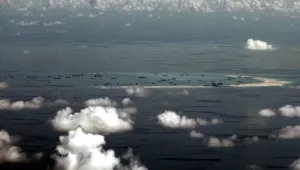 This photo taken through a glass window of a military plane shows China's alleged on-going reclamation of Mischief Reef in the Spratly Islands in the South China Sea on Monday, May 11, 2015. As China builds artificial islands in a vast resource-rich South China Sea, neighbors in Southeast Asia brace for possible conflict.(Ritchie B. Tongo/Pool Photo via AP)