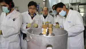 Unidentified International Atomic Energy Agency inspectors and Iranian technicians are on hand to cut the connections between the twin cascades for 20 percent uranium enrichment at the Natanz facility, about 200 miles south of Tehran, on Jan. 20, 2014. (AP Photo/IRNA, Kazem Ghane)