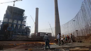 Workers lay cement to build a concrete structure at a coal-fired power plant