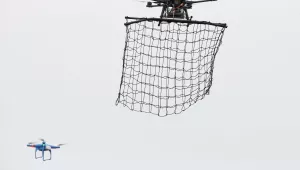 A drone Interceptor MP200, top, prepares to catch a drone DJI Phantom 2 with a net during a demonstration flight in La Queue-en-Brie, France, in 2015 (AP Photo/Francois Mori).