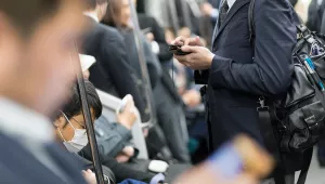 Commuters use mobile phones in Tokyo, Japan.