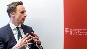 John Bew on the left and a crimson banner with the Belfer Center word mark on the right.