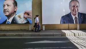  People walk past by an election poster of Turkey's president and ruling Justice and Development Party leader Recep Tayyip Erdogan, left, and Muharrem Ince, presidential candidate of the main opposition Republican People's Party, in Istanbul, Tuesday, June 19, 2018. 