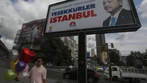 A day after the elections, people walk past a billboard with the image of Turkey's president Recep Tayyip Erdogan, in Istanbul, Monday, June 25, 2018.