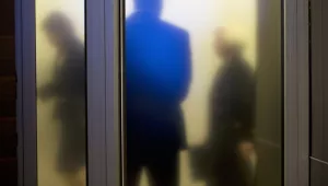 Federal Reserve employees walk past a frosted glass window on the way to a news conference, September 17, 2015.