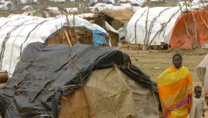 A woman walks with her child in a refugee camp in the western Darfur region of Sudan. This photograph was taken sometime in October of 2004.