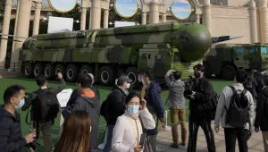 Visitors tour past military vehicles carrying the Dong Feng 41 and DF-17 ballistic missiles at the Beijing Exhibition Hall in Beijing on Oct. 12, 2022.