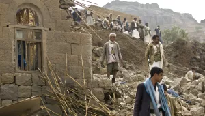 Yemenis stand amid the rubble of houses destroyed by Saudi-led airstrikes in a village near Sanaa, Yemen.