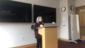 Sarah Ladislaw stands at podium