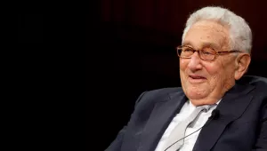 Henry Kissinger against a black background