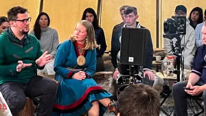 Speakers and audience sit in a circle inside a lavvu-style tent, in Norway.