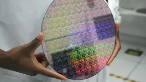 Someone holds a silicon wafer with chips etched into it as Vice President Kamala Harris tours a site where Applied Materials plans to build a $4 billion research facility on Monday, May 22, 2023, in Sunnyvale, Calif. 