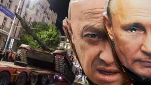 A composite image of a tank being loaded on a truck as people line the streets and two paper masks of Vladimir Putin and Yevgeny Prigozhin.