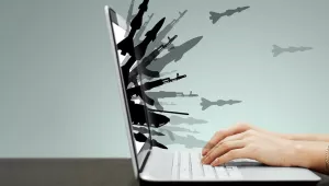 guns and missiles burst forth from a laptop screen