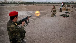 During a re-enactment in a park in southern Tehran, members of the Iranian Basij paramilitary force re-enact fighting in the 1980–88 war with Iraq.