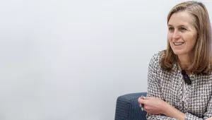 Catherine Wolfram sits on a blue chair.