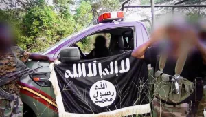 Al-Shabab fighters pose in front of a captured Kenyan security forces' truck after an ambush