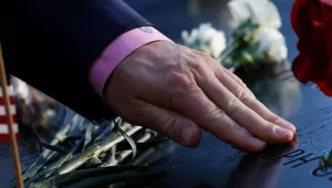 A person touches the name of a victim inscribed on the National September 11 Memorial on the 20th anniversary of the Sept. 11, 2001 attacks in New York on Saturday, Sept. 11, 2021.