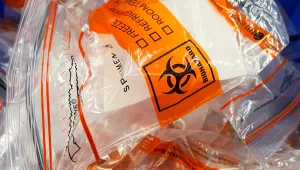 Discarded biohazard bags fill a trash can near a registration table for COVID-19 collection vials at Genetworx Clinical Lab in Richmond, Virginia, Friday April 24, 2020.