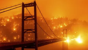embers light up a hillside behind the Bidwell Bar Bridge as the Bear Fire burns in Oroville, Calif.