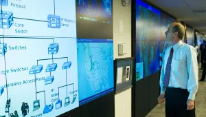 A man looks at large video screens in the Department of Homeland Security's National Cybersecurity and Communications Integration Center (NCCIC) in Arlington, Virginia, Wednesday, August 22, 2018.