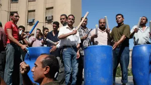  workers from the Misr Spinning and Weaving Factory in the northern industrial town of Mahalla el-Kobra, Egypt, beat on makeshift drums 