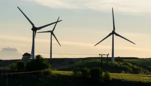 three wind turbines silhouetted against the sky