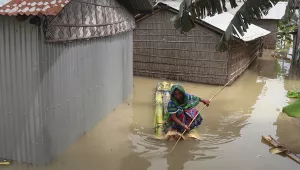 A woman rows a makeshift raft near her partially submerged house in Gagolmari village, Morigaon district, Assam, India, Tuesday, July 14, 2020.