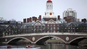  rowers paddle along the Charles River past the Harvard University campus