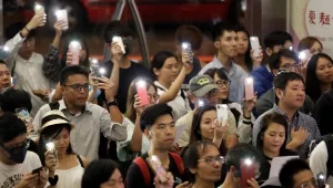 Supporters flash their smartphones lights as they join the protesters singing 