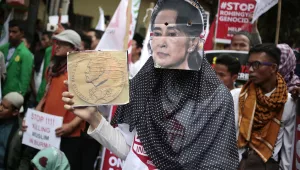 A Muslim woman wears a mask of  Aung San Suu Kyi