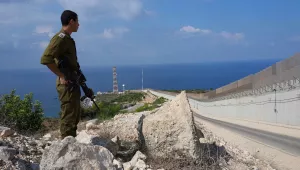 An Israeli soldier stands near the fence on the Israeli border with Lebanon 