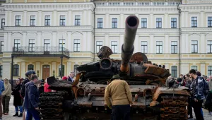 A man looks at a destroyed Russian tank placed as a symbol of war in downtown Kyiv, Ukraine