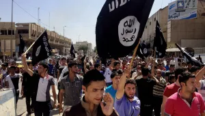 demonstrators chant pro-Islamic State group slogans as they carry the group's flags