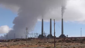 Three tall smokestacks emit plumes of steam and emissions