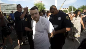 A man is arrested as the statue of Confederate General Robert E. Lee is removed in New Orleans